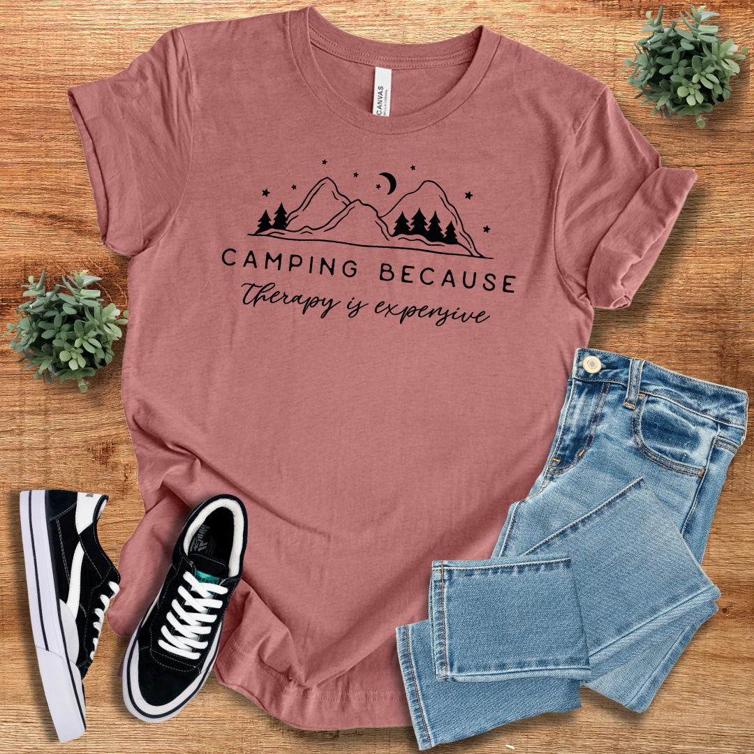 Mauve 'Camping Because Therapy is Expensive' T-shirt with a mountain and tree graphic. Soft and stylish unisex tee for camping and hiking fans.