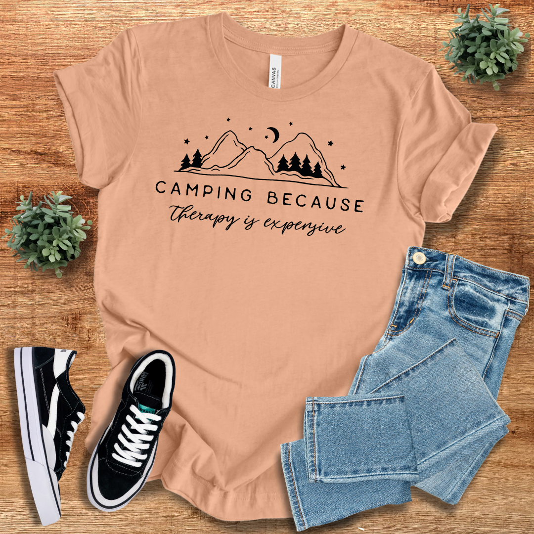 Peach 'Camping Because Therapy is Expensive' T-shirt with a nature-inspired graphic. Stylish and comfortable unisex tee for camping lovers.