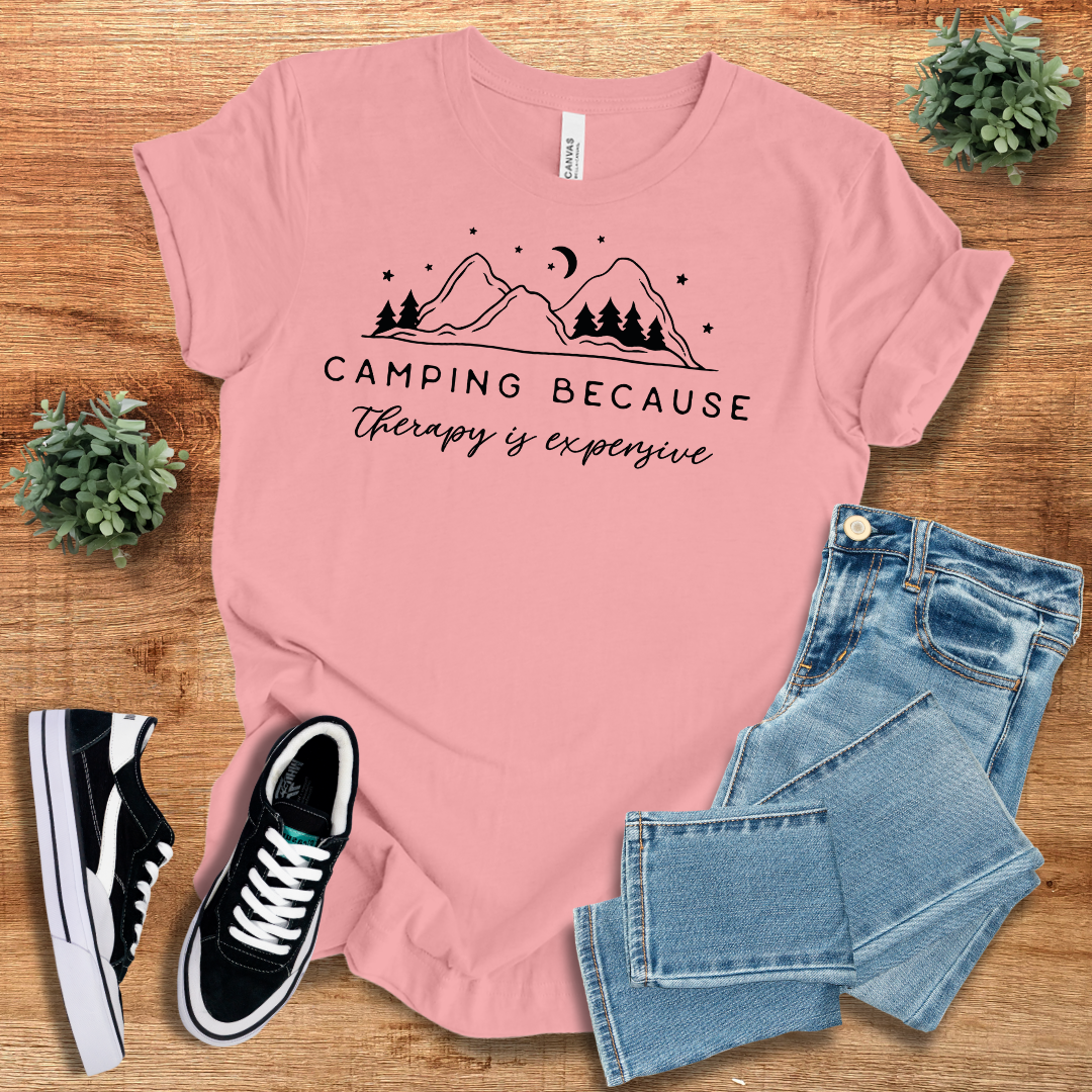 Pink 'Camping Because Therapy is Expensive' T-shirt featuring a nature-inspired design. Comfortable and breathable cotton tee for outdoor enthusiasts.