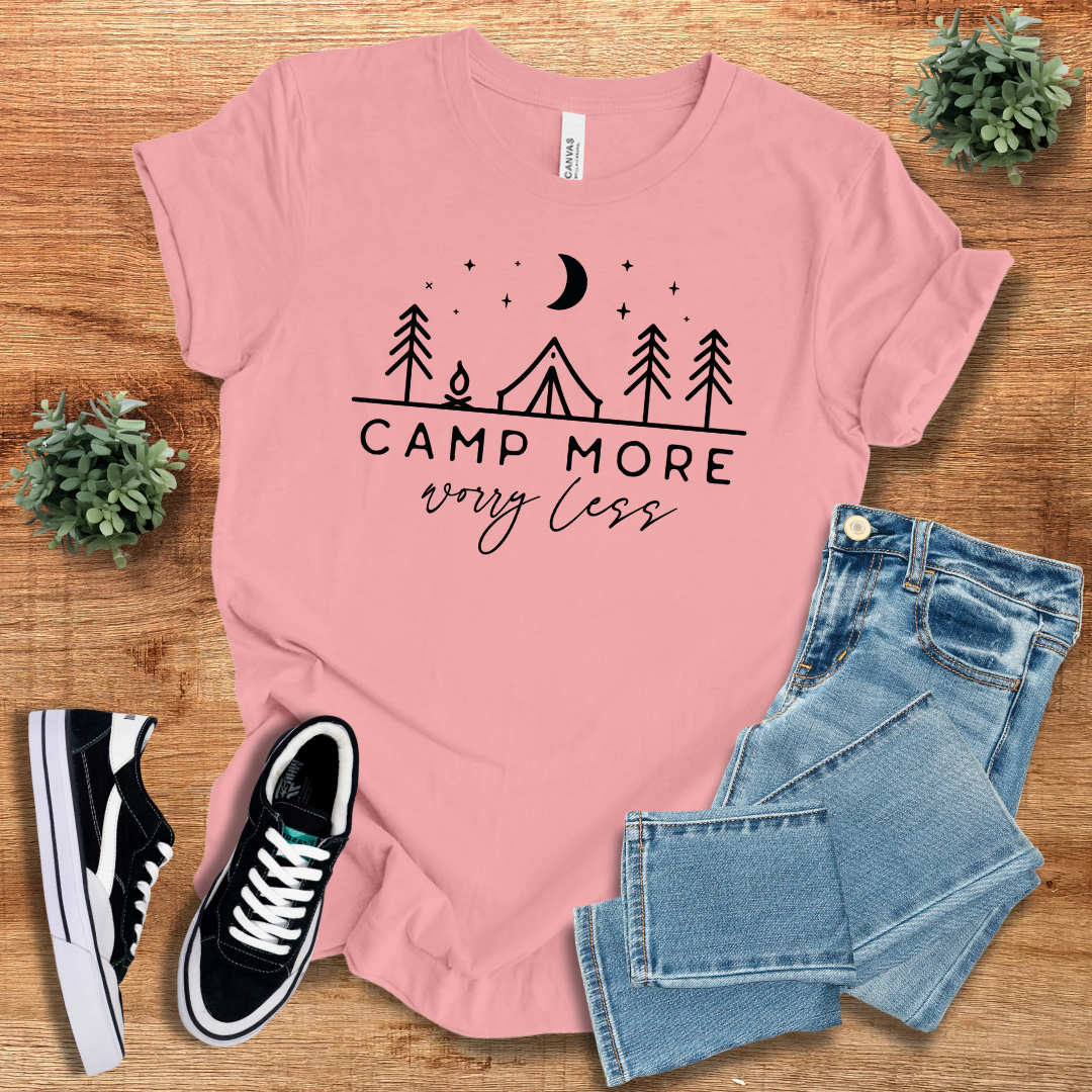 Soft pink 'Camp More Worry Less' t-shirt with a nature-inspired print. A lightweight and stylish tee for outdoor lovers and casual fashion.
