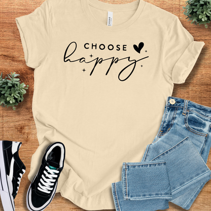 Soft-cream t-shirt with 'Choose Happy T‑Shirt' text, flat lay styled on a wooden surface.