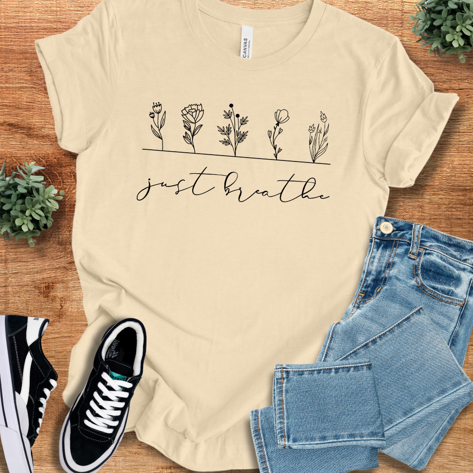 Beige 'Just Breathe with Wildflowers' t-shirt featuring a floral line art design. Ethically made, breathable cotton for a relaxed and stylish look.