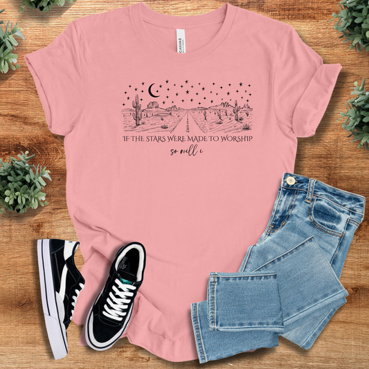 White t-shirt with '' text, flat lay styled on a wooden surface.