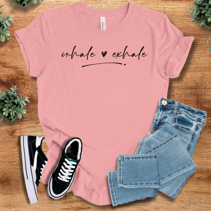 Heather-navy t-shirt with '' text, flat lay styled on a wooden surface.