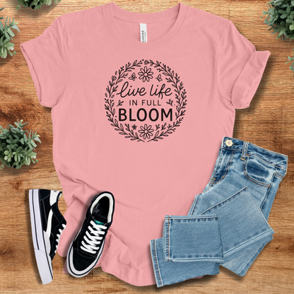 Yellow t-shirt with '' text, flat lay styled on a wooden surface.