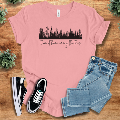 Heather-mauve t-shirt with '' text, flat lay styled on a wooden surface.