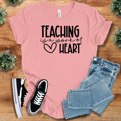 Heather-aqua t-shirt with '' text, flat lay styled on a wooden surface.