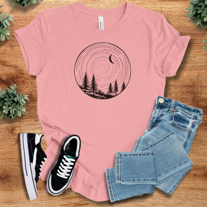 Heather-mauve t-shirt with '' text, flat lay styled on a wooden surface.