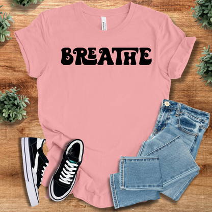 Heather-navy t-shirt with '' text, flat lay styled on a wooden surface.