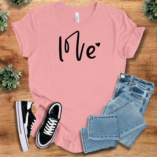Love Heart Tee in pink with black love graphic and heart accent. 100% cotton unisex t-shirt perfect for anniversaries or casual wear.