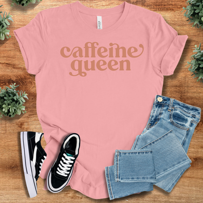 Heather-mauve t-shirt with '' text, flat lay styled on a wooden surface.