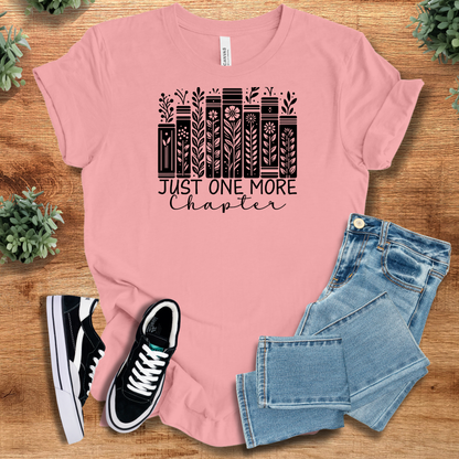 Heather-mauve t-shirt with '' text, flat lay styled on a wooden surface.