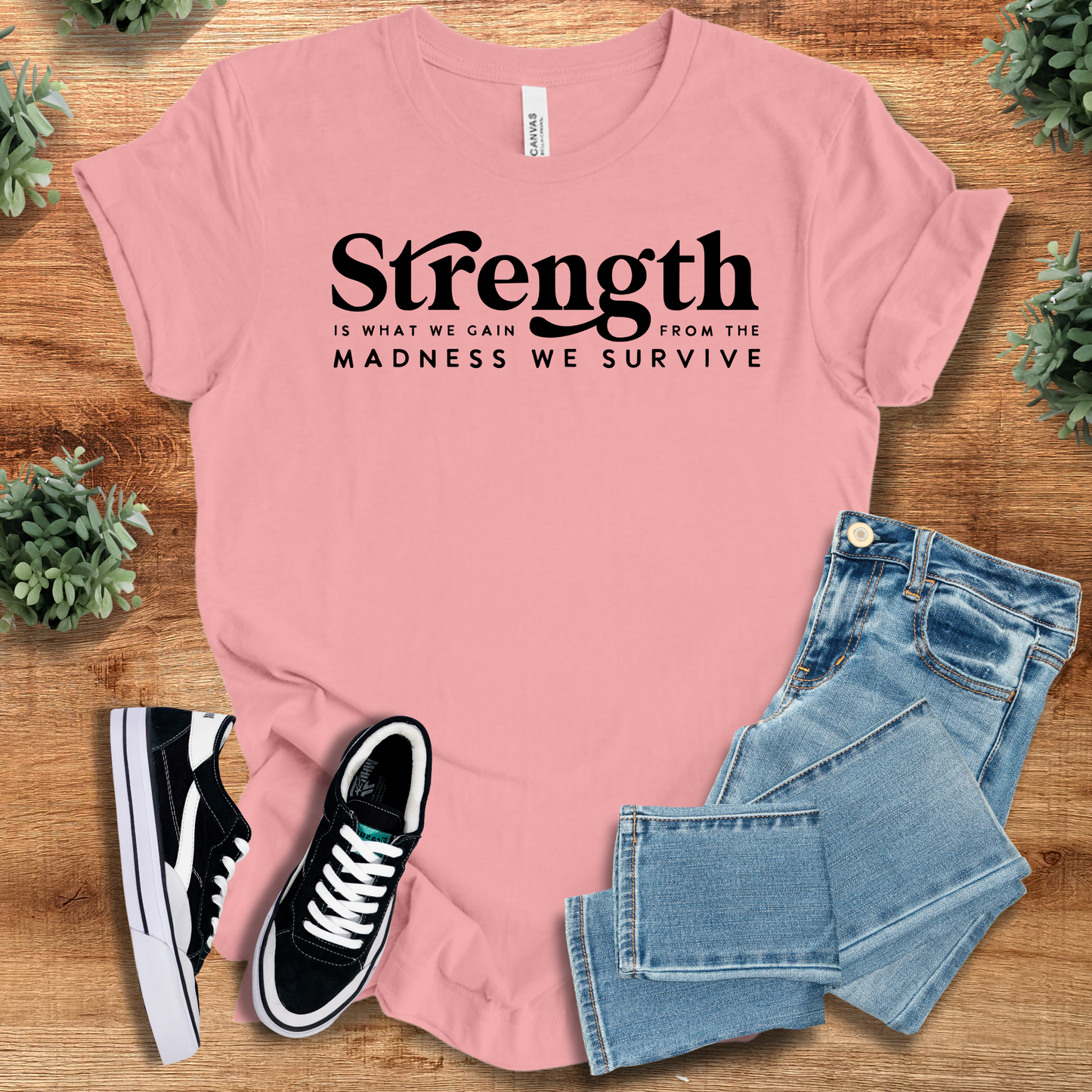 Light pink unisex strength t-shirt with bold black quote, styled with jeans and sneakers. Encouraging gift tee for resilience and mindset shift.