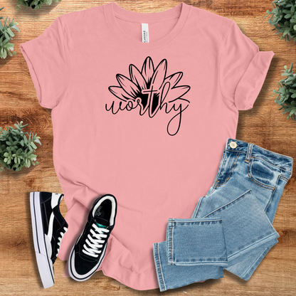 Heather-aqua t-shirt with '' text, flat lay styled on a wooden surface.