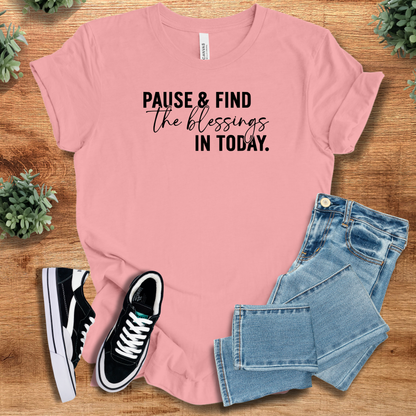 Heather-navy t-shirt with '' text, flat lay styled on a wooden surface.