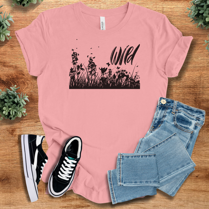 Heather-mauve t-shirt with '' text, flat lay styled on a wooden surface.