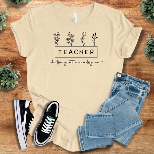 Beige Teacher Impact T-Shirt with floral design and 'helping little minds grow' quote. 100% cotton, casual fit for educators.