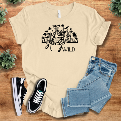 Heather-mauve t-shirt with '' text, flat lay styled on a wooden surface.