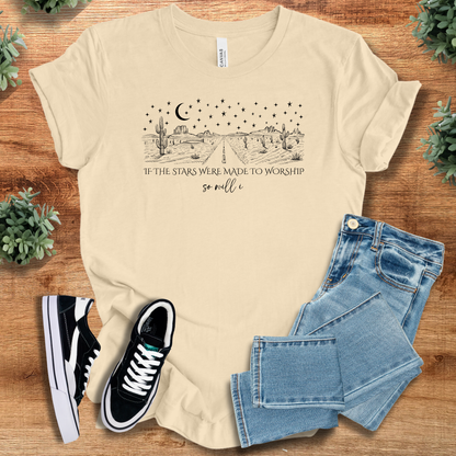 White t-shirt with '' text, flat lay styled on a wooden surface.