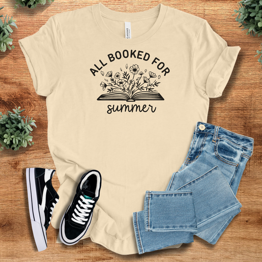 All Booked for Summer T-Shirt in cream with floral book graphic, styled with jeans and sneakers. Ideal book lover tee for casual summer outfits.