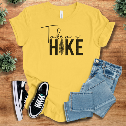 Military-green t-shirt with '' text, flat lay styled on a wooden surface.