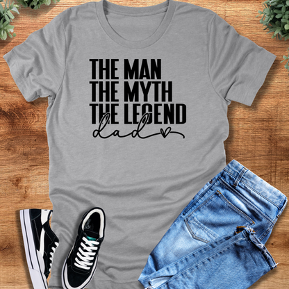Black t-shirt with '' text, flat lay styled on a wooden surface.