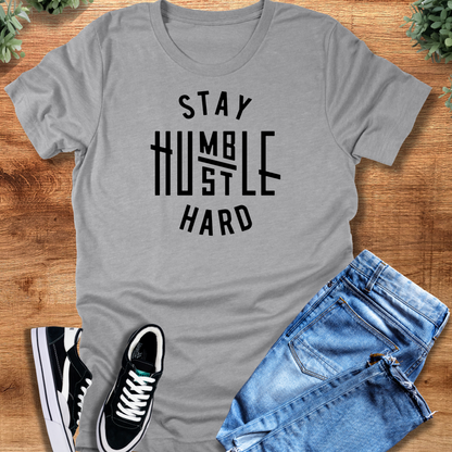 Black t-shirt with '' text, flat lay styled on a wooden surface.
