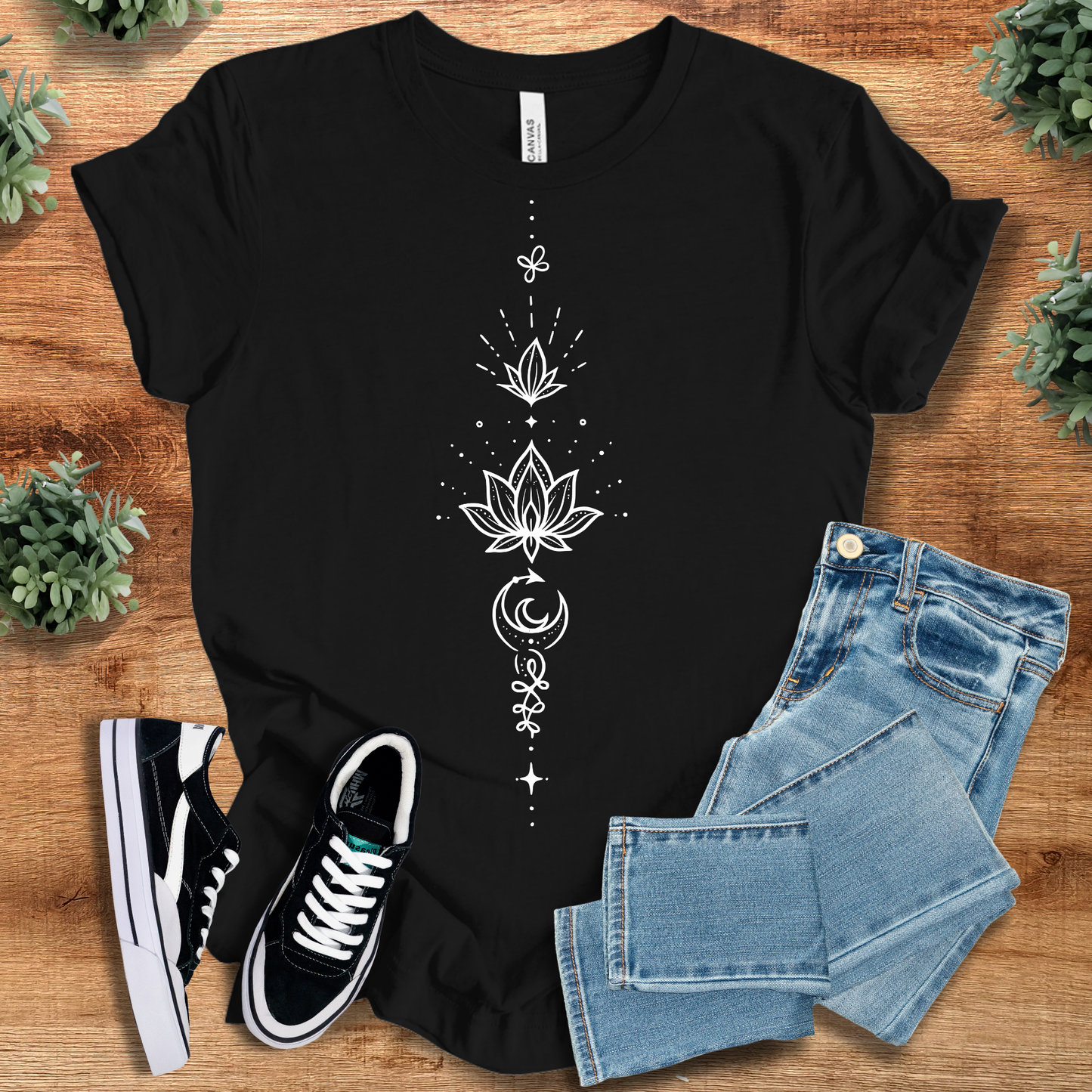 Black t-shirt with 'Lotus Tee' text, flat lay styled on a wooden surface.