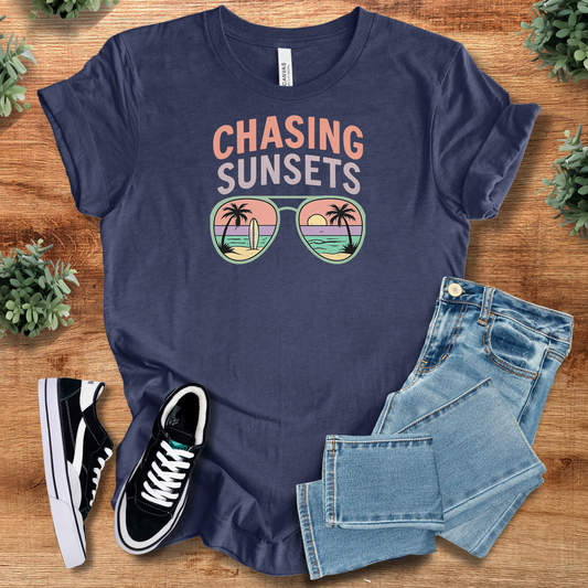Chasing Sunsets Shades T‑Shirt in navy blue on soft Bella+Canvas 3001 fabric, styled with jeans and sneakers. Ideal comfy unisex graphic tee.
