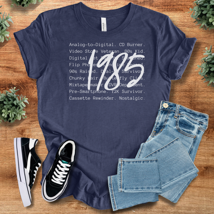 Black t-shirt with '' text, flat lay styled on a wooden surface.