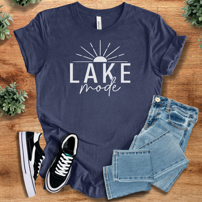 Heather-mauve t-shirt with '' text, flat lay styled on a wooden surface.