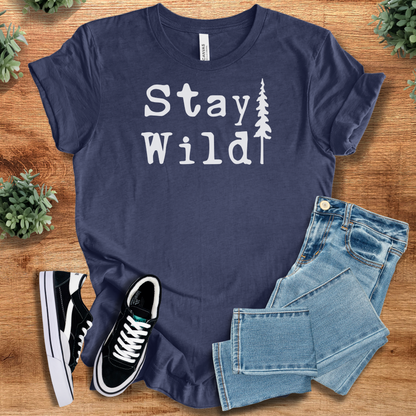 Heather-navy t-shirt with 'Stay Wild Tree T‑Shirt' text, flat lay styled on a wooden surface.