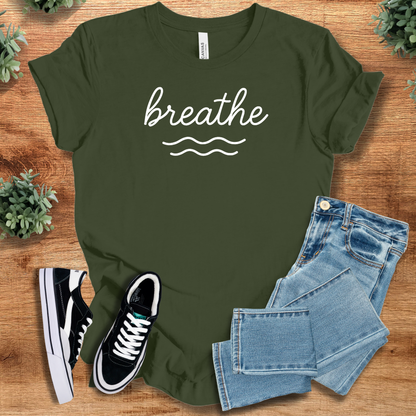 Heather-navy t-shirt with '' text, flat lay styled on a wooden surface.
