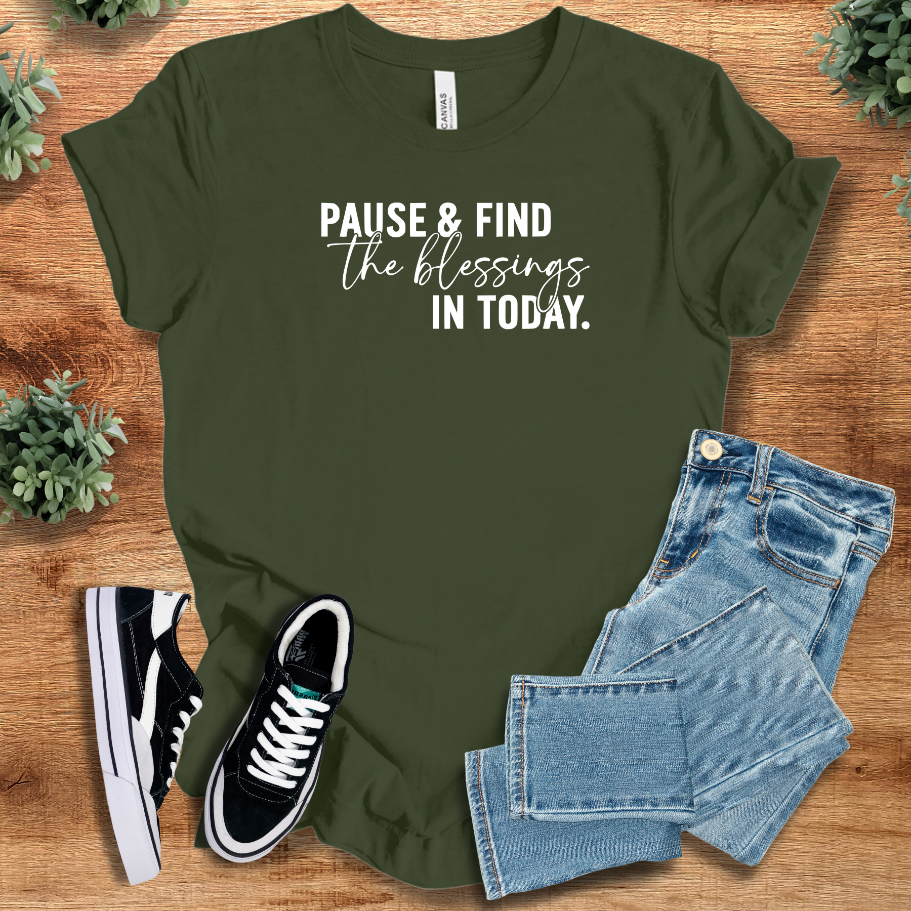 Heather-navy t-shirt with '' text, flat lay styled on a wooden surface.