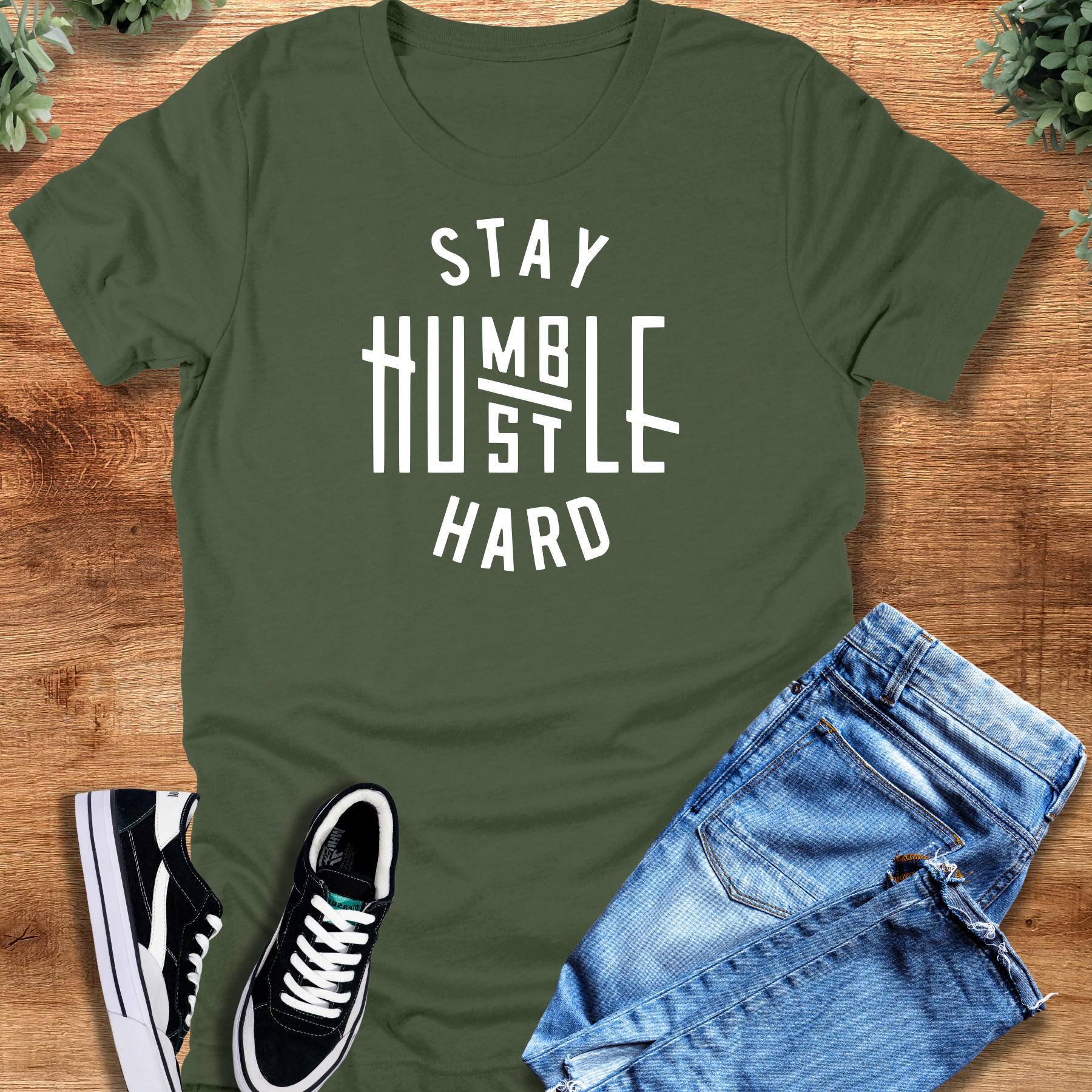 Black t-shirt with '' text, flat lay styled on a wooden surface.