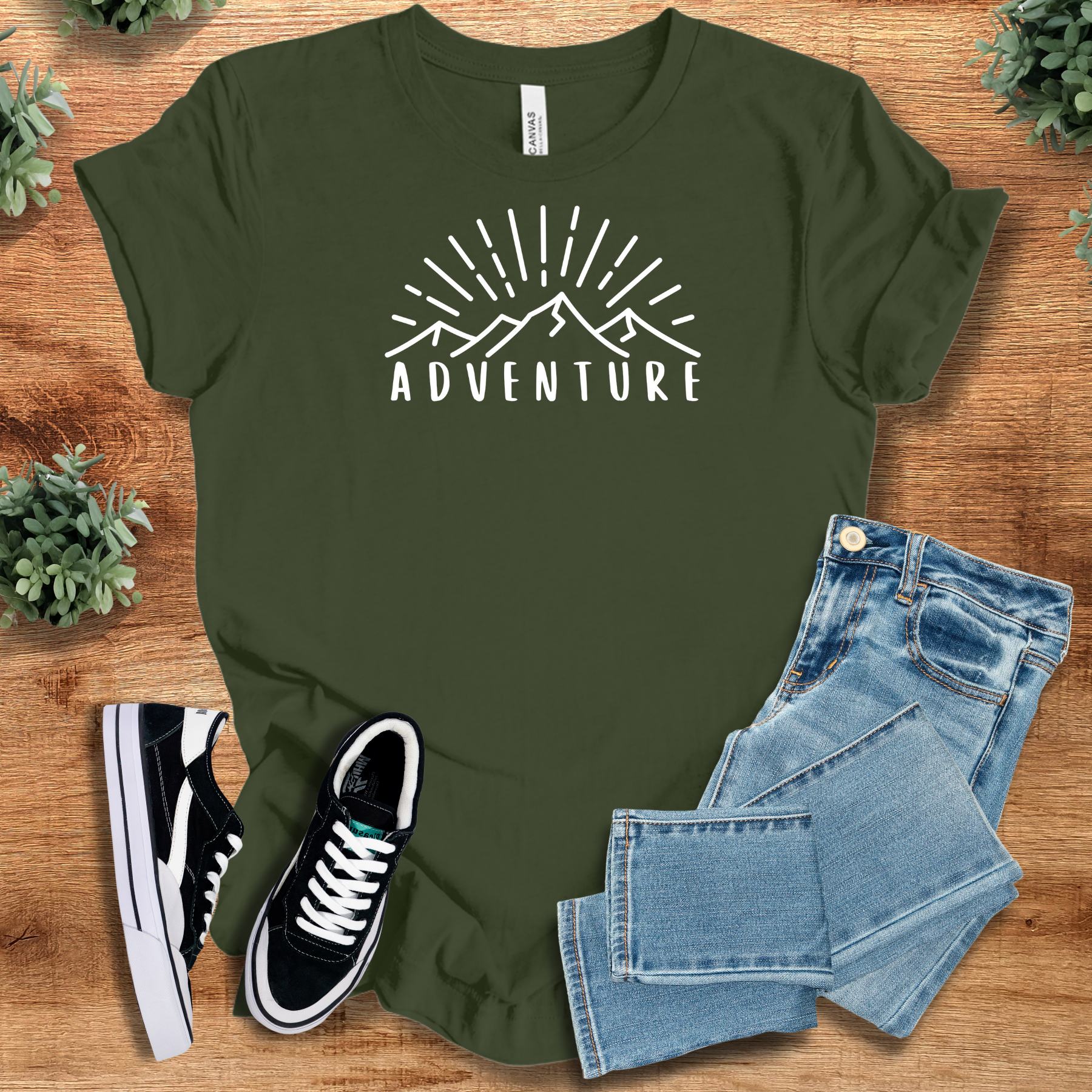 Pink t-shirt with '' text, flat lay styled on a wooden surface.