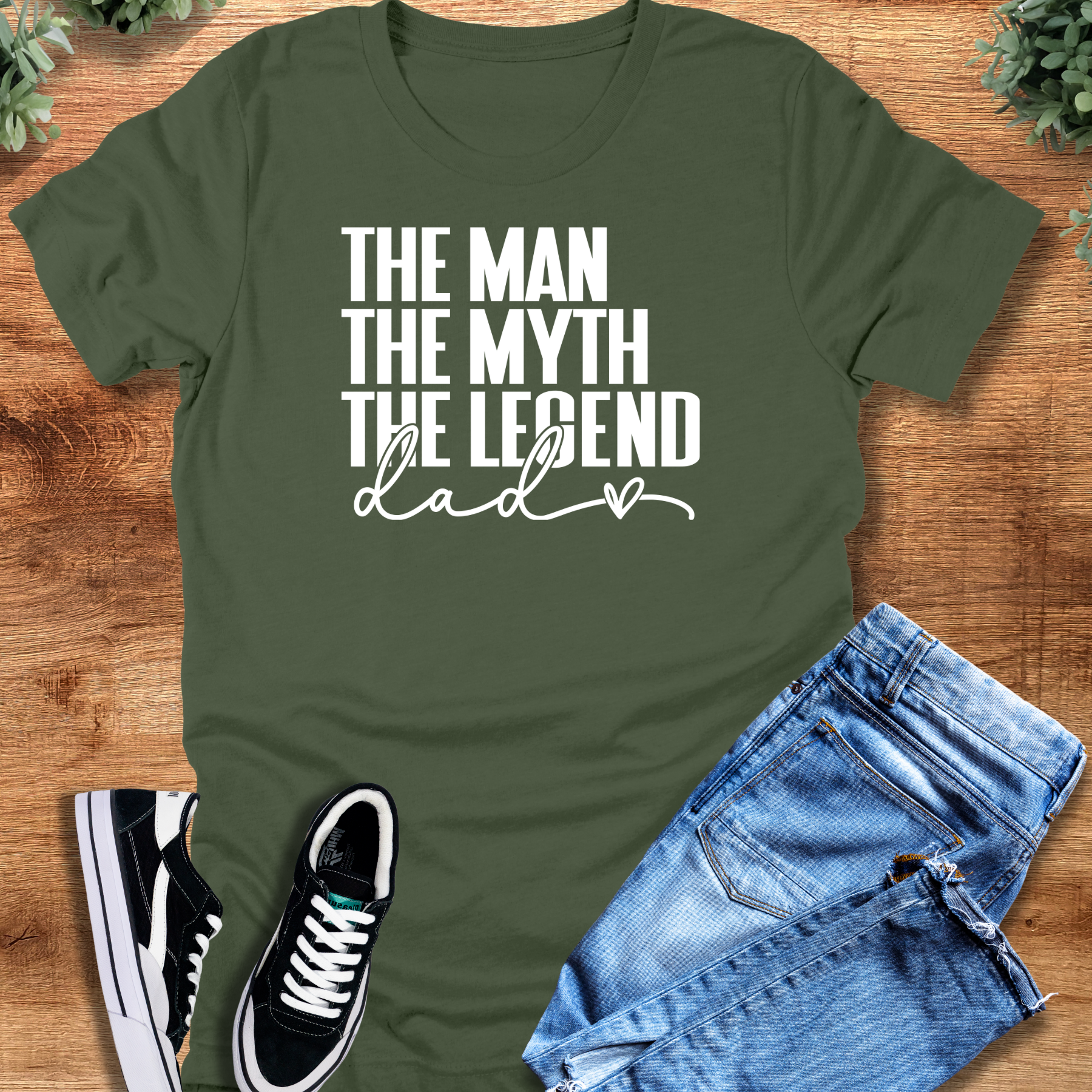 Black t-shirt with '' text, flat lay styled on a wooden surface.