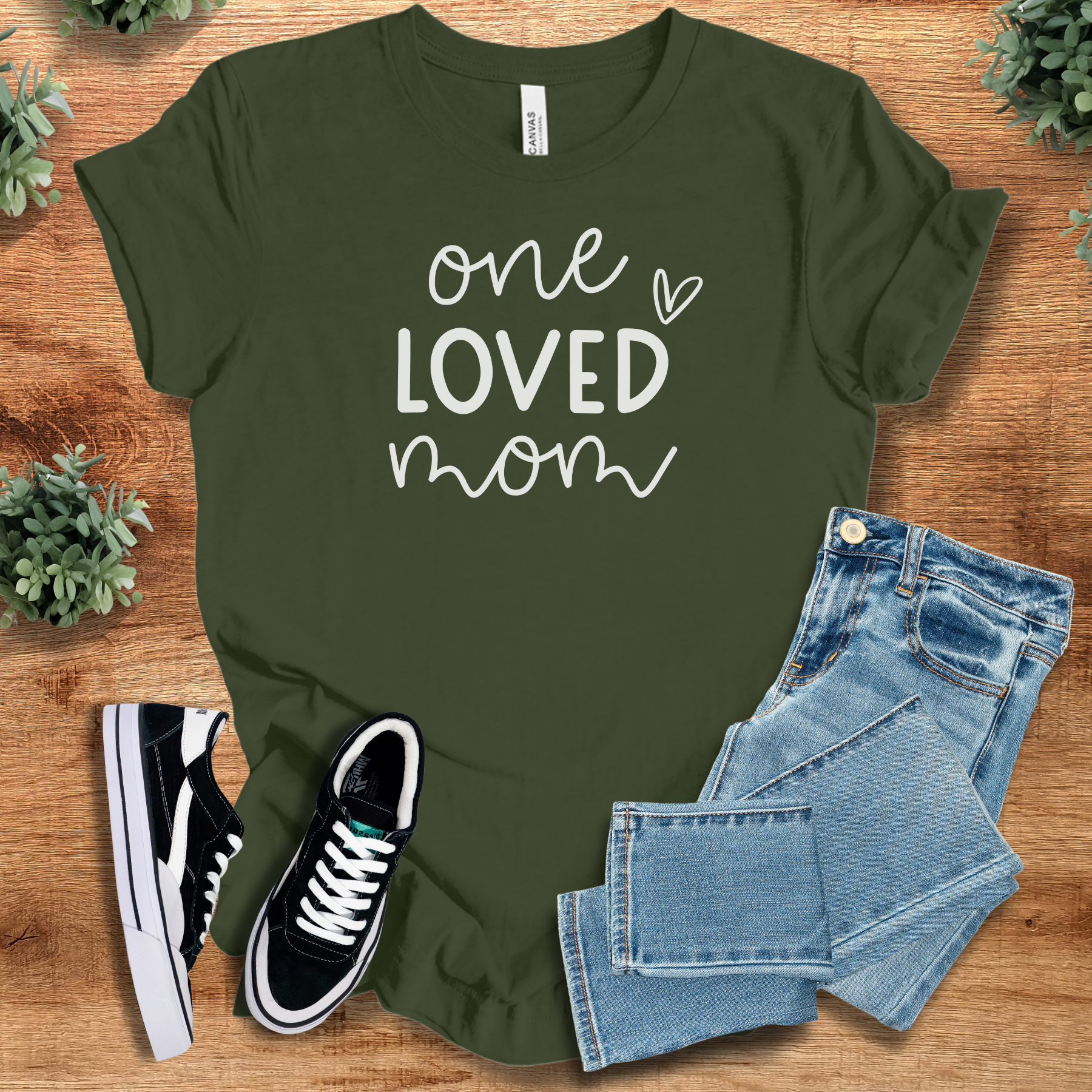 Heather-aqua t-shirt with '' text, flat lay styled on a wooden surface.