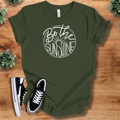 Yellow t-shirt with '' text, flat lay styled on a wooden surface.