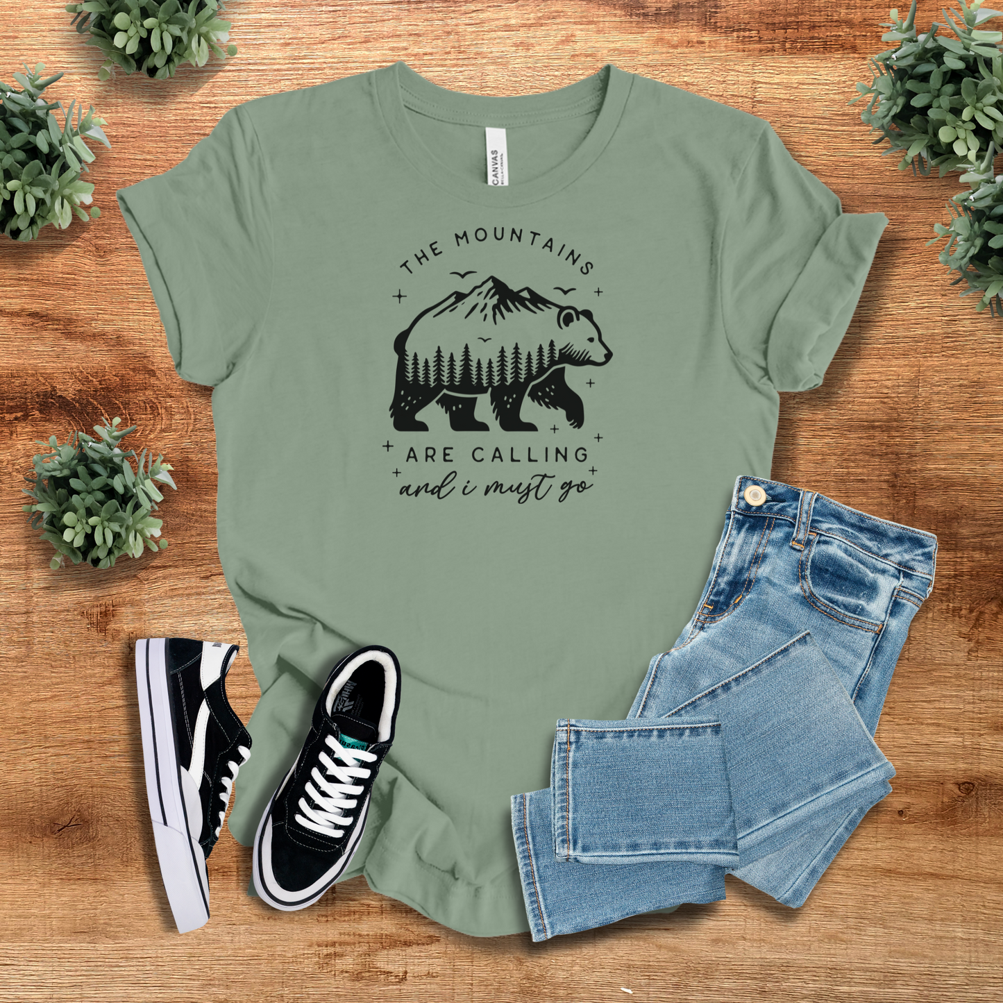 Sage green nature-inspired t-shirt with a bear and mountain graphic. A stylish and comfy adventure tee for camping and hiking lovers.