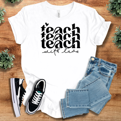White t-shirt with 'Teach with Love Tee' text, flat lay styled on a wooden surface.