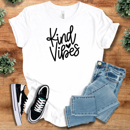 Black t-shirt with '' text, flat lay styled on a wooden surface.