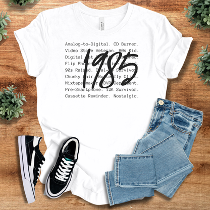 Black t-shirt with '' text, flat lay styled on a wooden surface.